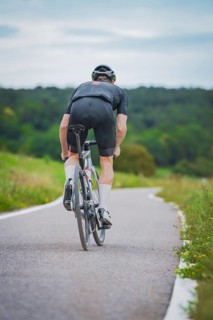 Cyclist in sporty clothes riding on a country road through green nature, Triathlon, Calw, Germany