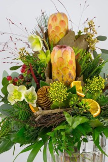 Detailed close-up of a floral arrangement with protea, Christmas rose and berries, exotically