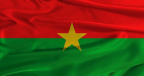 Flag of Burkina Faso with fabric textured background. Close up of National flag of Burkina Faso
