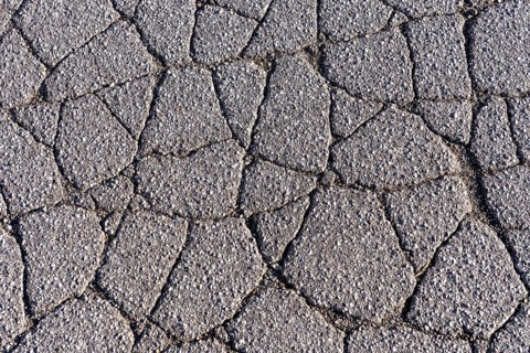Asphalt surface, floor, with many small cracks, roadway, parking lot