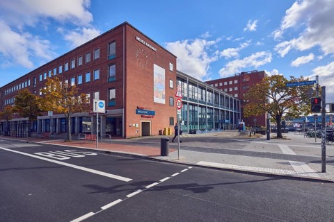 New town hall, brick building, modern architecture, façade with windows, bus lane marking,