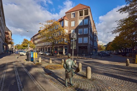 Bronze sculpture newspaper boy, sculptor Frauke Wehberg, street made of paving stones, general