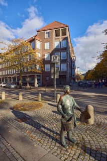 Bronze sculpture newspaper boy, sculptor Frauke Wehberg, street made of paving stones, general