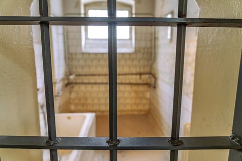 View through the grid into a bathroom in the former Stasi prison Bautzen II, now a memorial in