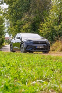 Black SUV on a green forest path surrounded by nature and trees, Cupra electric car, e-car sharing,
