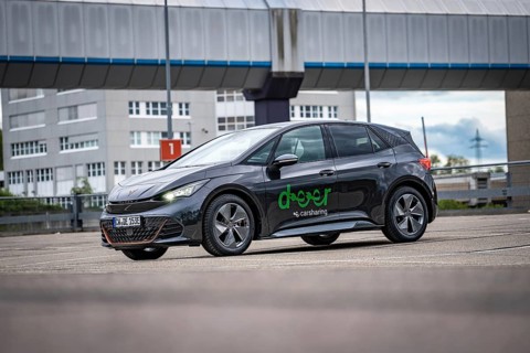 A modern Cupra stands in a parking lot in an urban area under a cloudy sky, electric car Cupra,
