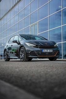 An elegant car depicted on asphalt in front of a glass façade, electric car Cupra, e-car sharing,