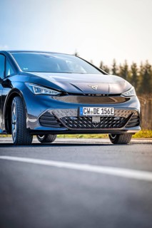 Close-up black car on a road with forest in the background, electric car Cupra, e-car sharing,