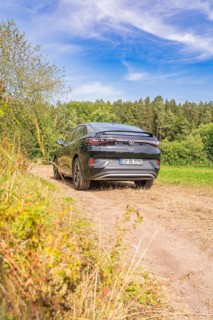 A black Volkswagen on a rural path with blue sky and forest, Cupra electric car, e-car sharing,