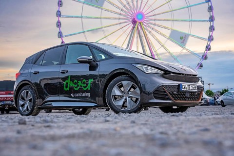 Car in front of a Ferris wheel at dusk at a fair, electric car Cupra, e-car sharing, Calw, Germany