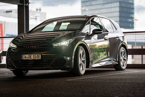 Black car sharing car in front of glass architecture, modern design and urban style, Cupra electric
