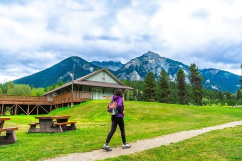 Female tourist walking on a path in mount robson provincial park with visitor center and picnic