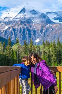 Mother and son are enjoying breathtaking views of mount robson, the highest peak in the canadian
