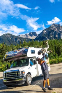 Father lifting his son in the air, celebrating their adventure in mount robson provincial park,