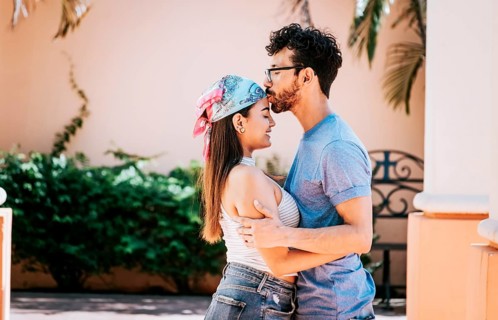 Cute couple embracing the boyfriend kisses the girl forehead. Portrait of beautiful couple in love.