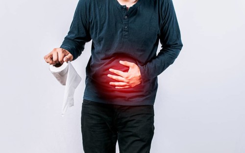 Person with toilet paper with stomach problems on isolated background, Concept of a person with