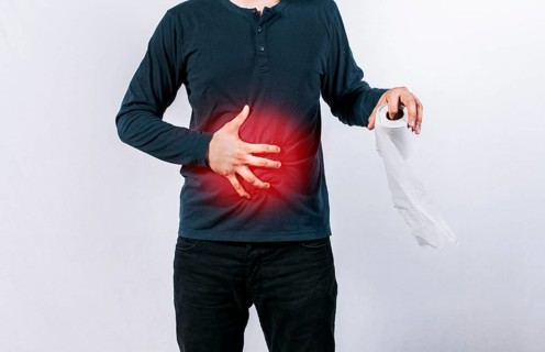 Man with stomach problems holding toilet paper, Person with toilet paper with stomach problems on