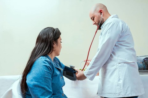 Measuring blood pressure to patient in the office, Nutritionist man measuring blood pressure to