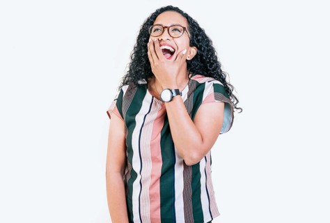 Funny young afro woman laughing on isolated background. Young woman in glasses laughing out loud