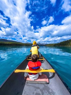 Tourists paddling a canoe on beautiful maligne lake in jasper national park, alberta, canada,