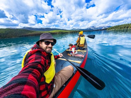Family enjoying a sunny day canoeing on maligne lake in jasper national park, alberta, canada,