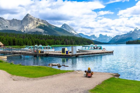 Tourists are enjoying the breathtaking view of maligne lake with tour boats and spirit island in
