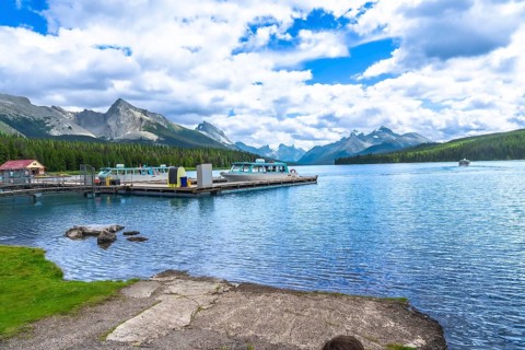Tour boats are docked at maligne lake in jasper national park with a stunning view of the canadian