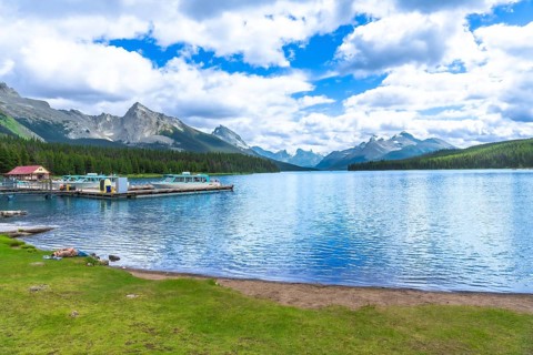 Tranquil maligne lake in jasper national park reflecting the majestic canadian rockies, with boats