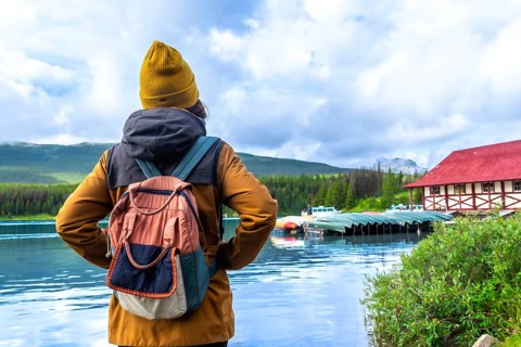 Female tourist with a backpack admiring the stunning view of maligne lake and its historic