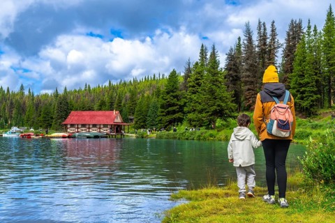 Mother and son admiring the beautiful landscape of maligne lake with its boathouse and colorful