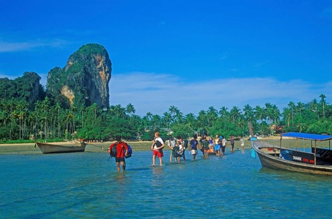 Tourists wade to their boat taxi that brings them back to Krabi, two years in front of the tsunami,