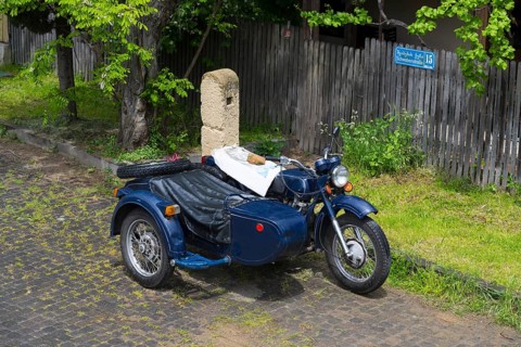 Blue motorcycle with sidecar parked on a cobblestone road, motorcycle team, model of the Ukrainian