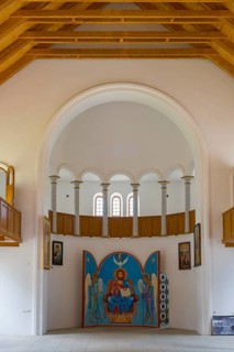Church interior with icon wall under large white arches. Harmonious symmetry in space, German