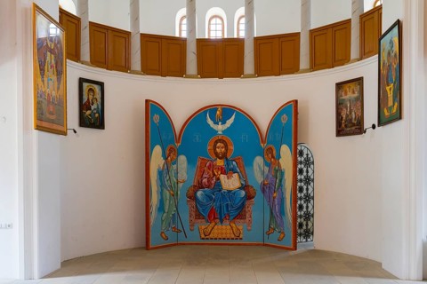 Iconostasis with central image of Christ and angels. Bright church surrounded by religious