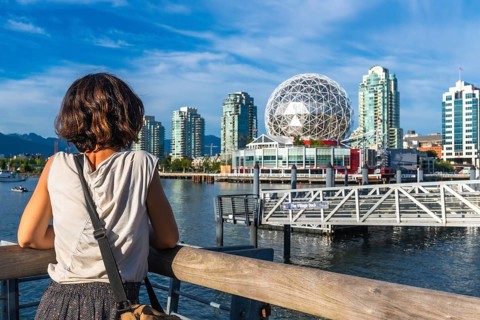 Young woman tourist is enjoying the cityscape of vancouver, british columbia, with science world