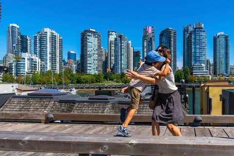 Mother and her son are sharing a tender hug on a wooden pier in vancouver's yaletown neighborhood,