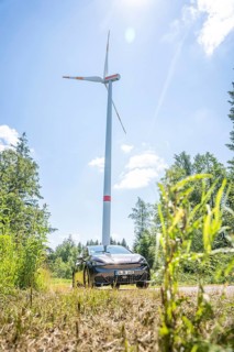 Car standing under a large wind turbine in sunny weather in a field, Deer E-Car Sharing, Cupra