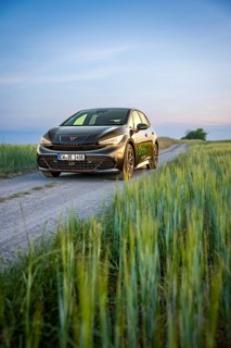 Car on a dirt road with tall grass at dusk, Deer E-car sharing, Cupra electric car, Germany