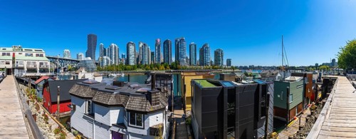 Panoramic view of colorful floating homes in false creek with modern and historical buildings of