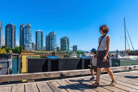 Mother and her son enjoying a sunny summer day walking along the wooden boardwalk of granville