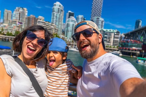 Happy family enjoying a sunny summer day while taking a selfie with the stunning vancouver, british