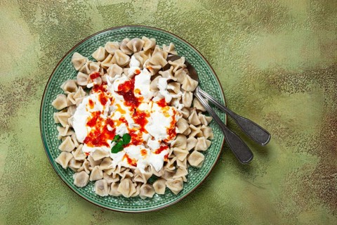 The dish features a generous serving of Turkish dumplings topped with velvety yogurt and a drizzle
