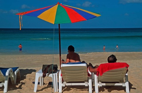 People holding umbrellas and sun loungers on Karon Beach, two years in front of the tsunami, Ko
