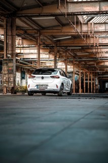 White car parked in empty industrial building, urban industrial look, deer e-car sharing,