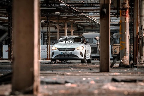 A car is parked in an empty, structured factory building, accentuated by light and shadow, Deer