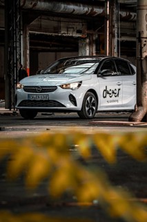 White Opel car sharing vehicle in industrial plant with yellow foreground, Deer E-Car Sharing,