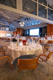 A festively decorated room with set tables and stylish lighting, Christmas party Dekra