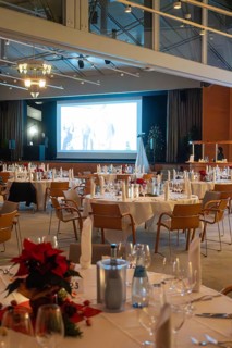 Elegant banquet hall with set tables and large screen in a festive atmosphere, Christmas party