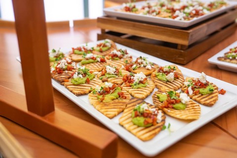 Appetizers with avocado and tomato served appealingly on white plates, Christmas party Dekra
