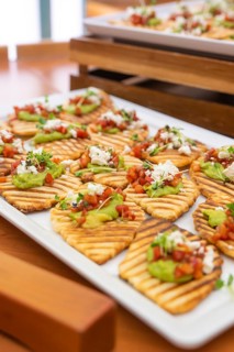 Creatively prepared tartines with guacamole and fresh garnish on wooden trays, Christmas party